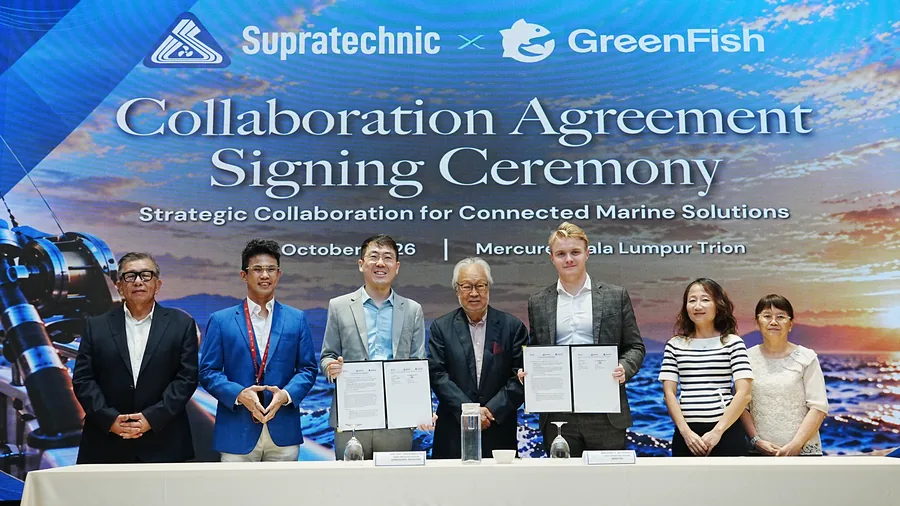 Seven representatives standing in a row, the two signatories holding the signed agreement folders